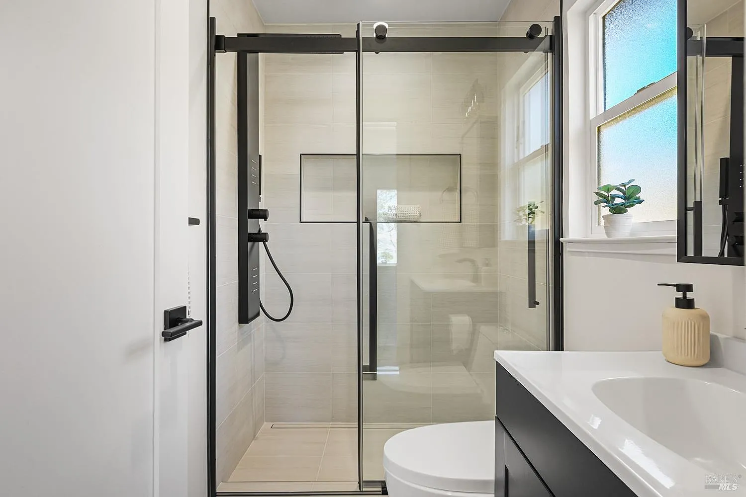 bathroom remodel with glass shower and white vanity
