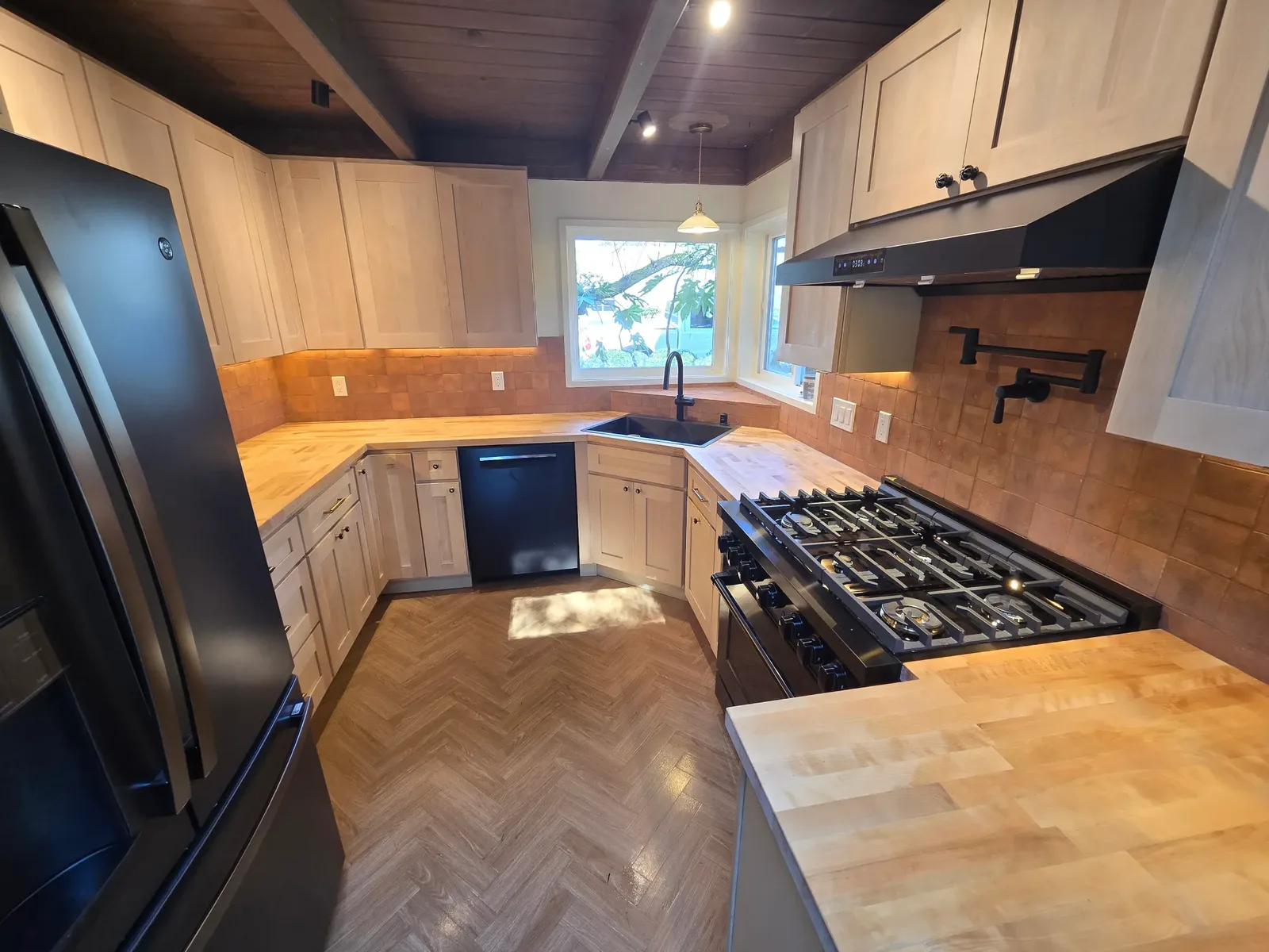 kitchen remodel with wood countertops, new cabinetry, and black appliances